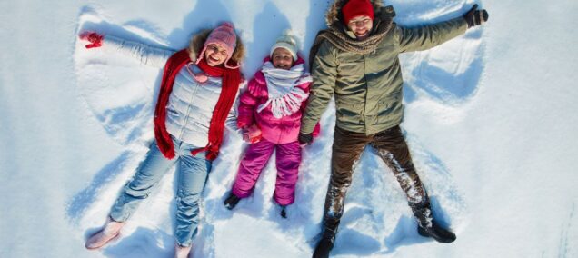 family making snow angels canva
