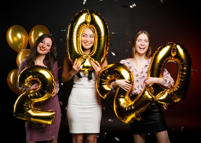 photo of young women holding year 2020 ballons